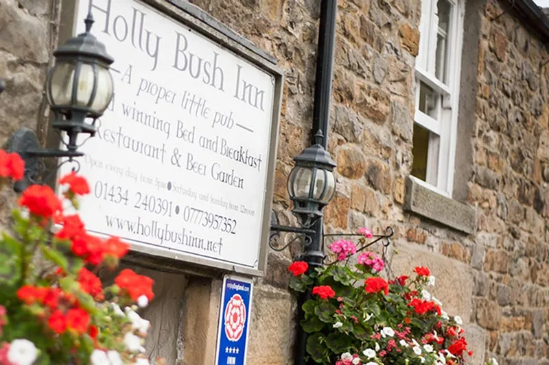 The Holly Bush Inn signage about the main entrance.