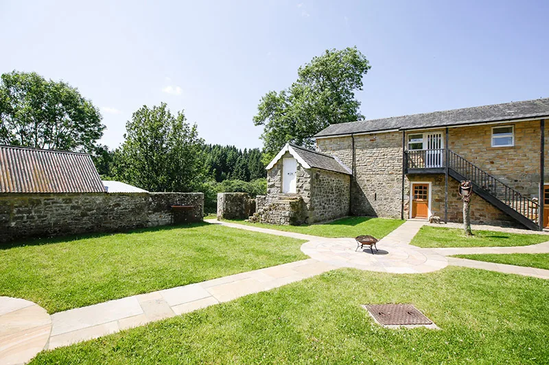 Neat garden area with accommodation in the background.